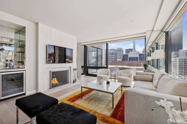 611 Washington St Unit 2505, San Francisco, CA 94111 - living area with beverage cooler, wood finished floors, a lit fireplace, and a wall of windows