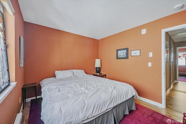 bedroom featuring hardwood / wood-style flooring and a baseboard radiator