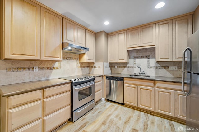 kitchen featuring backsplash, sink, light hardwood / wood-style floors, and stainless steel appliances