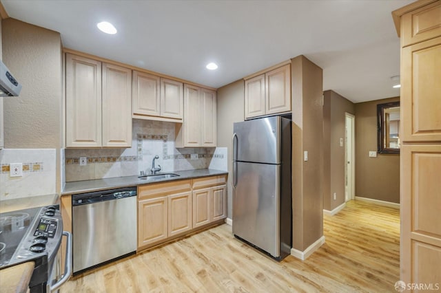 kitchen with light brown cabinets, sink, light wood-type flooring, and appliances with stainless steel finishes