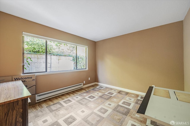 spare room featuring light wood-type flooring and a baseboard radiator