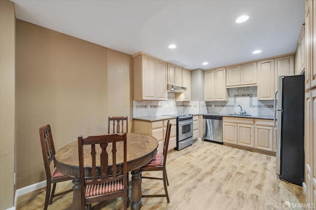 kitchen featuring stainless steel appliances, light wood-type flooring, light brown cabinetry, sink, and decorative backsplash