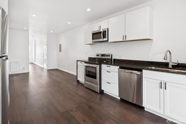 63-65 Jersey St, San Francisco, CA 94114 - kitchen featuring appliances with stainless steel finishes, recessed lighting, dark wood-style flooring, white cabinetry, and dark stone counters