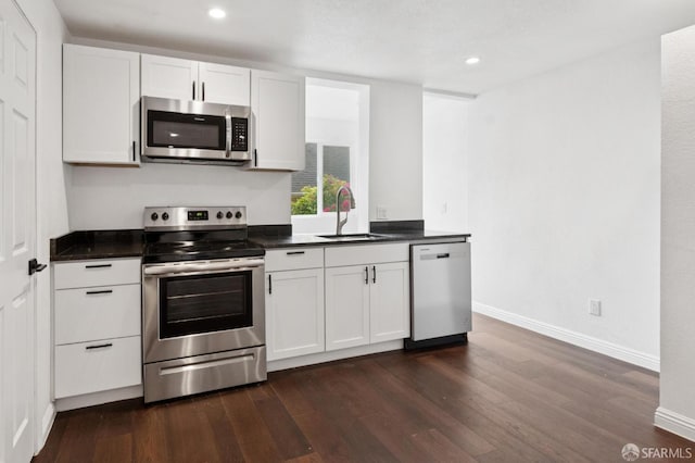 63-65 Jersey St, San Francisco, CA 94114 - kitchen with appliances with stainless steel finishes, dark countertops, dark wood-style flooring, white cabinetry, and recessed lighting