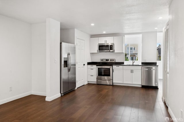 63-65 Jersey St, San Francisco, CA 94114 - kitchen with appliances with stainless steel finishes, dark countertops, dark wood-type flooring, white cabinets, and recessed lighting