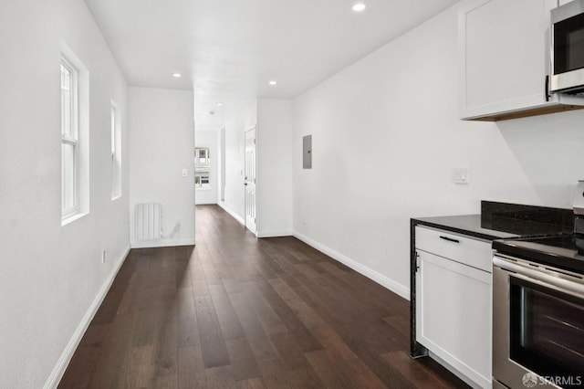 63-65 Jersey St, San Francisco, CA 94114 - kitchen with stainless steel appliances, radiator heating unit, white cabinetry, recessed lighting, and dark wood-style flooring