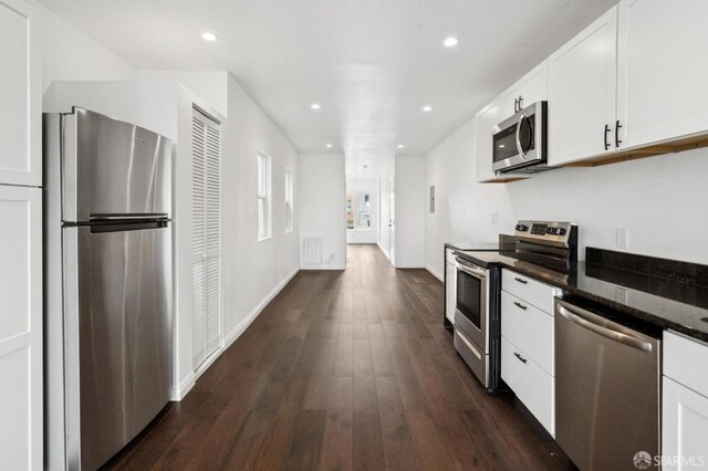 63-65 Jersey St, San Francisco, CA 94114 - kitchen with appliances with stainless steel finishes, white cabinetry, dark wood-style flooring, recessed lighting, and dark stone counters