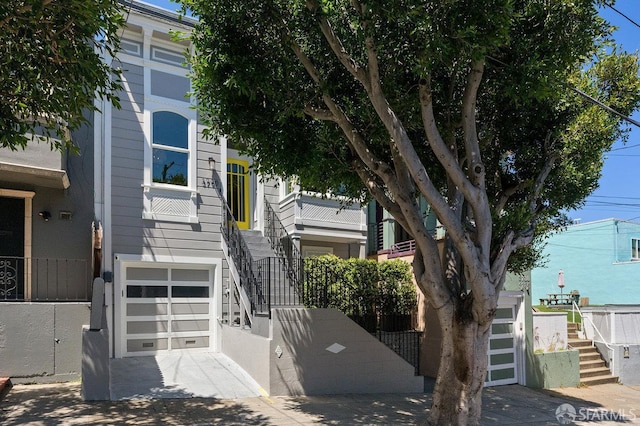 3790 Cesar Chavez St, San Francisco, CA 94110 - view of front of property featuring stairway, an attached garage, and concrete driveway