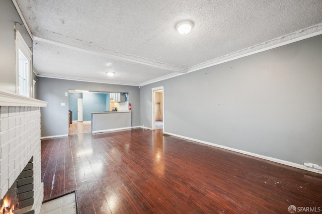 unfurnished living room featuring baseboards, a brick fireplace, wood finished floors, and crown molding