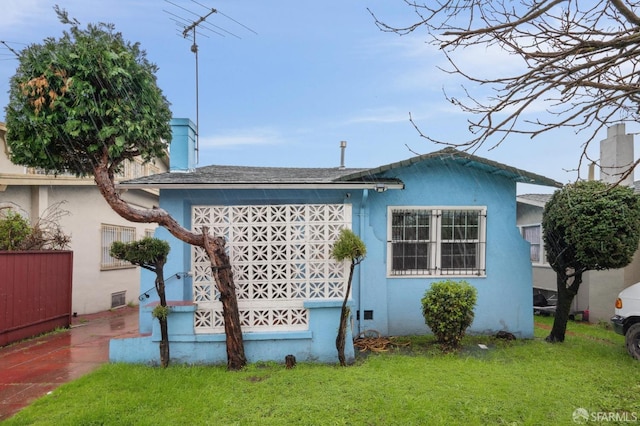 view of side of property featuring a lawn and stucco siding