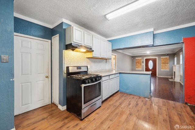 kitchen featuring light countertops, gas stove, a peninsula, and white cabinets