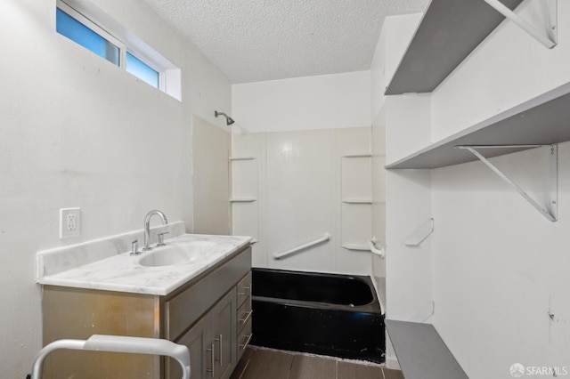 bathroom featuring bathing tub / shower combination, wood finished floors, a textured ceiling, and vanity