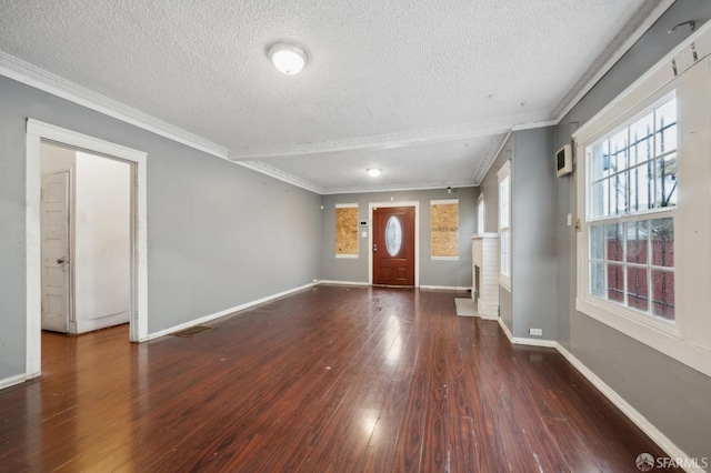 entrance foyer with crown molding, visible vents, dark wood-type flooring, a textured ceiling, and baseboards