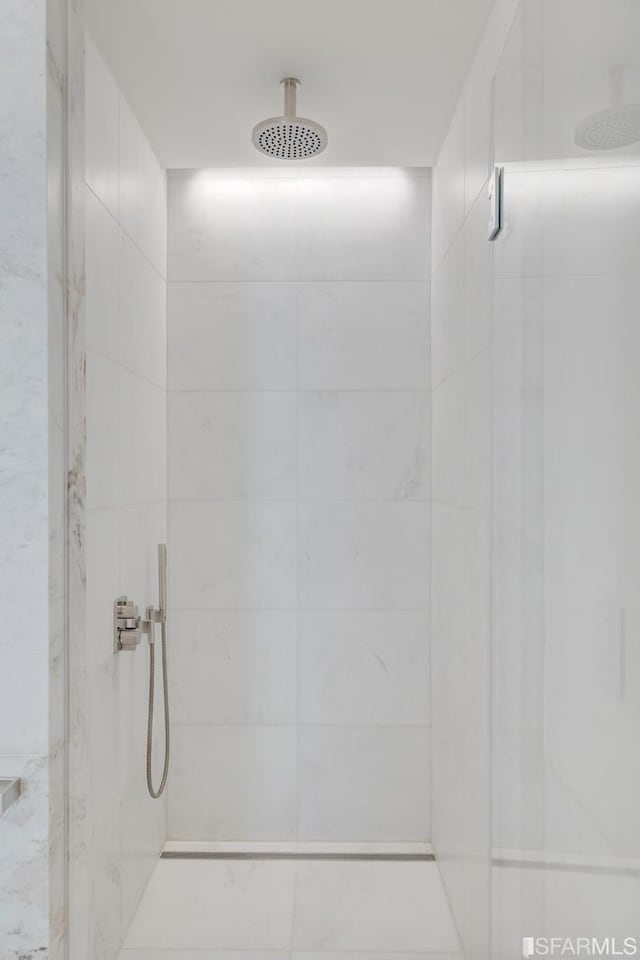 interior details featuring tiled shower