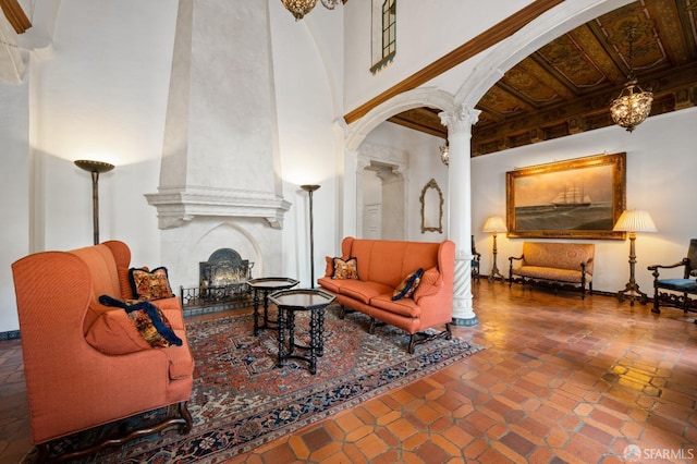 living room featuring decorative columns, tile patterned floors, and a fireplace