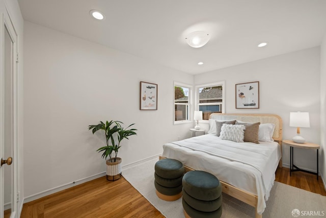 bedroom with wood finished floors, recessed lighting, and baseboards