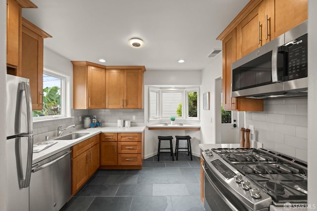 kitchen featuring a sink, decorative backsplash, visible vents, light countertops, and appliances with stainless steel finishes