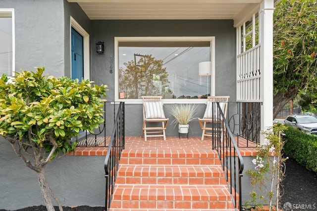 entrance to property with stucco siding and covered porch