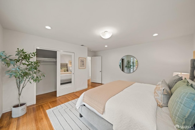 bedroom with light wood-style floors, a closet, recessed lighting, and baseboards