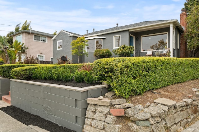 view of front of property with stucco siding and a chimney