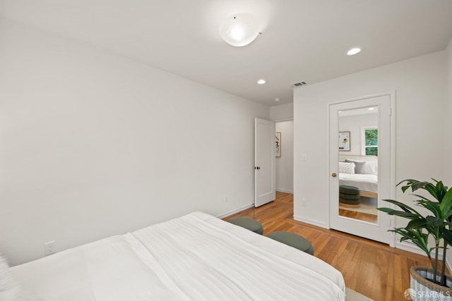 bedroom featuring wood finished floors, recessed lighting, visible vents, and baseboards