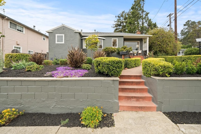 view of front of home with stucco siding and fence