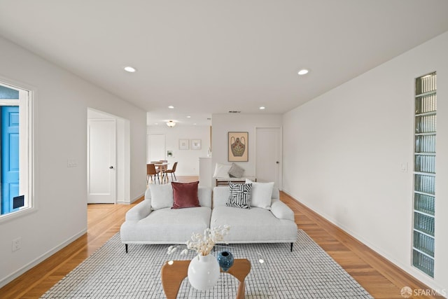 living room featuring light wood finished floors, recessed lighting, and baseboards