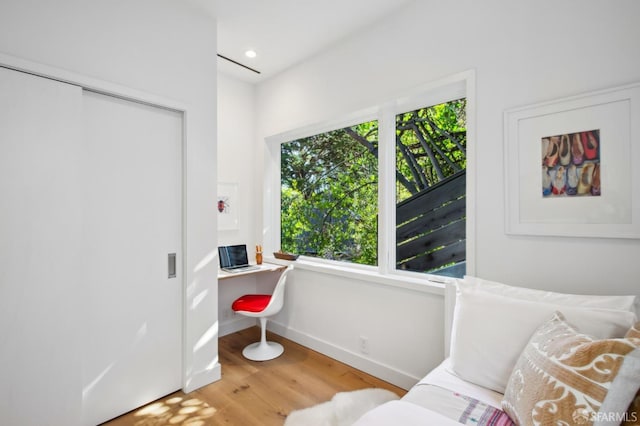 bedroom with hardwood / wood-style floors and built in desk