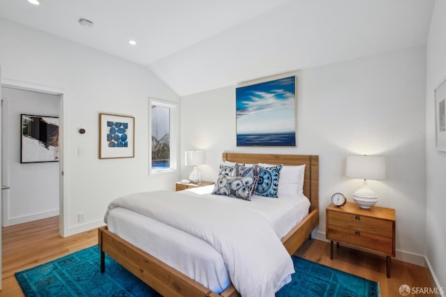 bedroom with lofted ceiling and hardwood / wood-style flooring