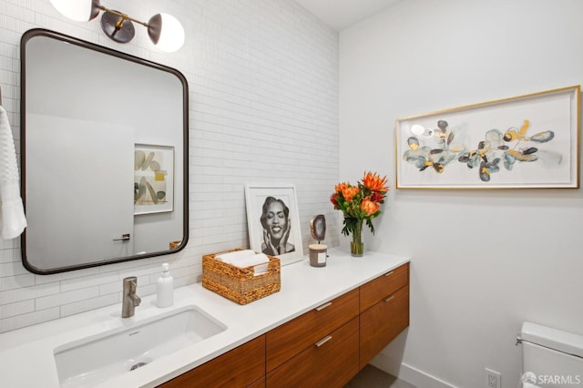 bathroom featuring vanity, backsplash, and toilet