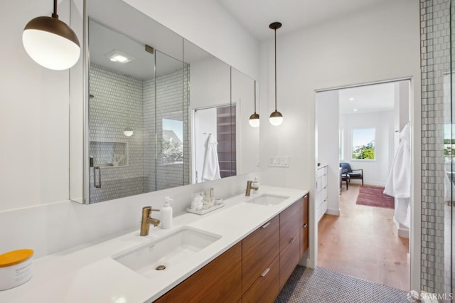 bathroom with hardwood / wood-style flooring, vanity, and an enclosed shower