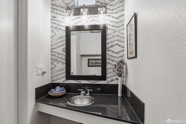 bathroom featuring a textured wall and vanity