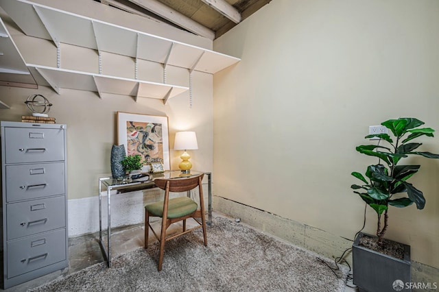 office with unfinished concrete floors and beamed ceiling