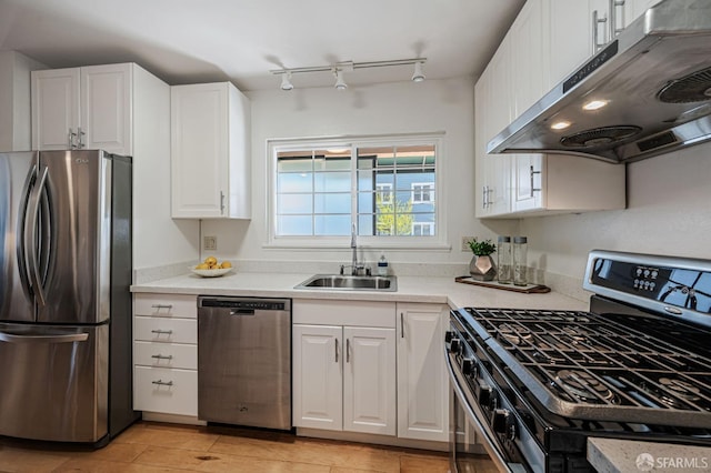 kitchen featuring white cabinets, under cabinet range hood, a sink, and appliances with stainless steel finishes