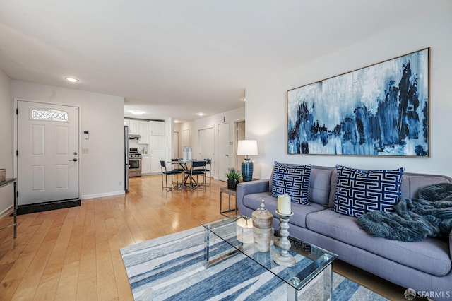 living area with light wood-style floors and baseboards