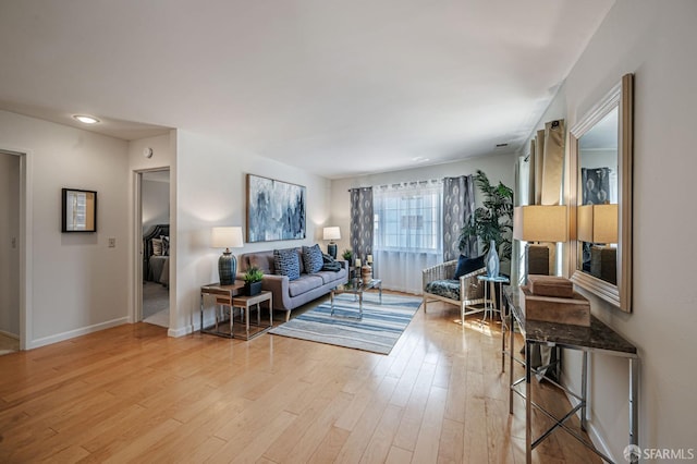living area featuring baseboards and wood finished floors