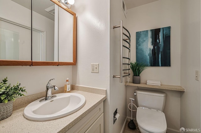 bathroom featuring vanity, visible vents, and toilet