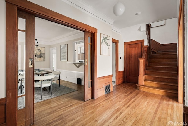 foyer featuring ornamental molding and light hardwood / wood-style floors