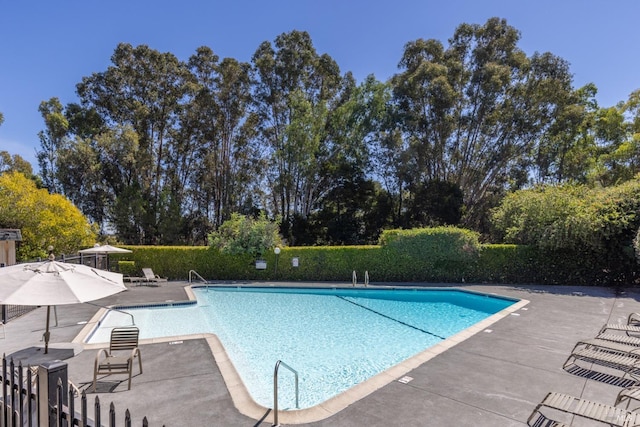 community pool with a patio and fence