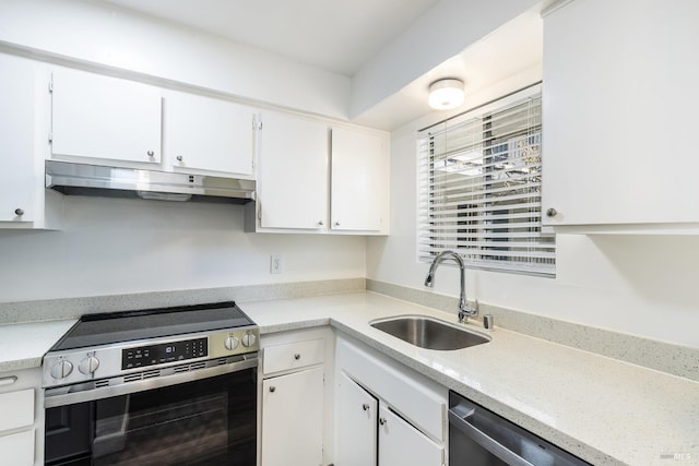 kitchen featuring under cabinet range hood, a sink, white cabinets, light countertops, and appliances with stainless steel finishes