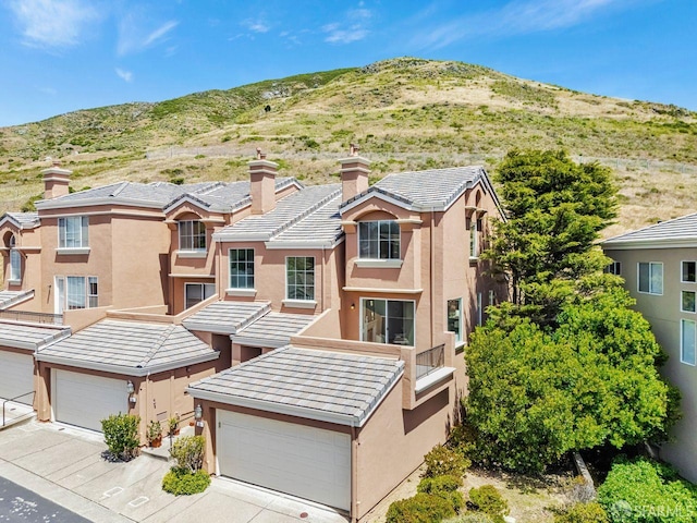 32 Highcrest Ln, South San Francisco, CA 94080 - view of front facade with stucco siding, a mountain view, a garage, and concrete driveway