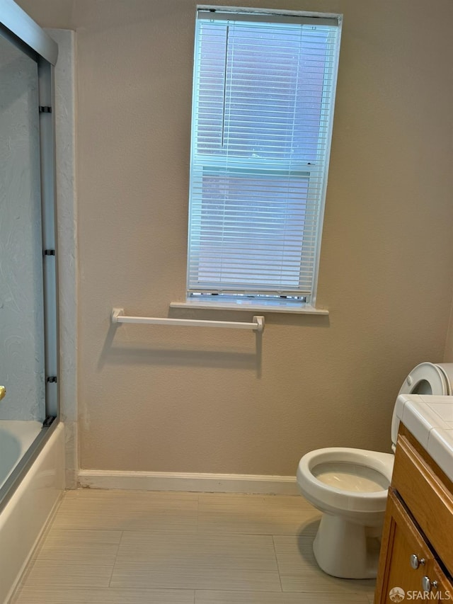 full bathroom with toilet, bath / shower combo with glass door, and vanity