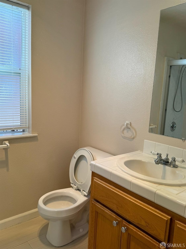 bathroom featuring hardwood / wood-style flooring, an enclosed shower, vanity, and toilet