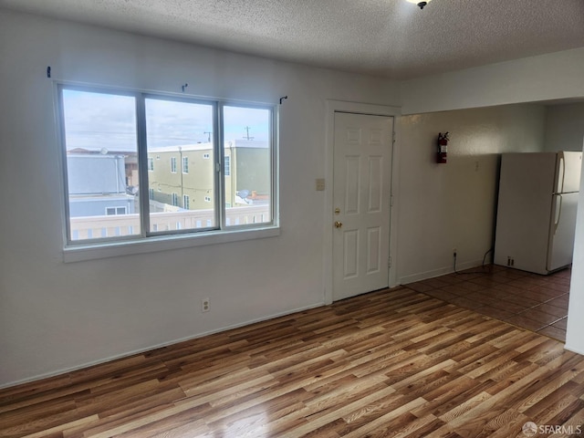 spare room featuring hardwood / wood-style floors and a textured ceiling