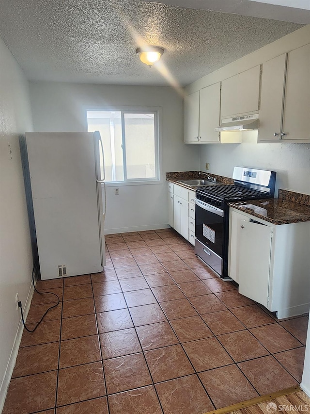 kitchen with white cabinets, a textured ceiling, white refrigerator, and stainless steel stove