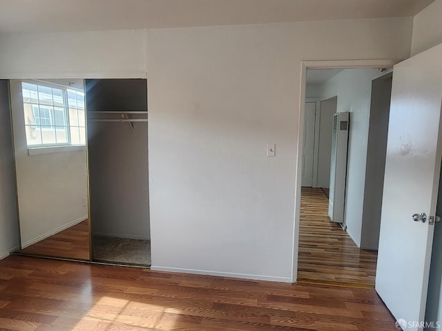 unfurnished bedroom featuring hardwood / wood-style flooring and a closet