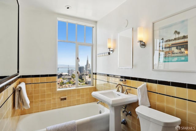 1101 Green St Unit 1402, San Francisco, CA 94109 - full bath with a bath, toilet, tile walls, a wainscoted wall, and a city view