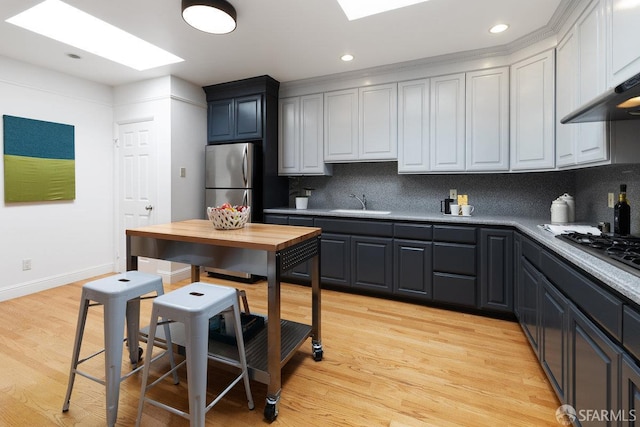 1751 25th Ave, San Francisco, CA 94122 - kitchen with gas stovetop, backsplash, light wood-style flooring, recessed lighting, and freestanding refrigerator