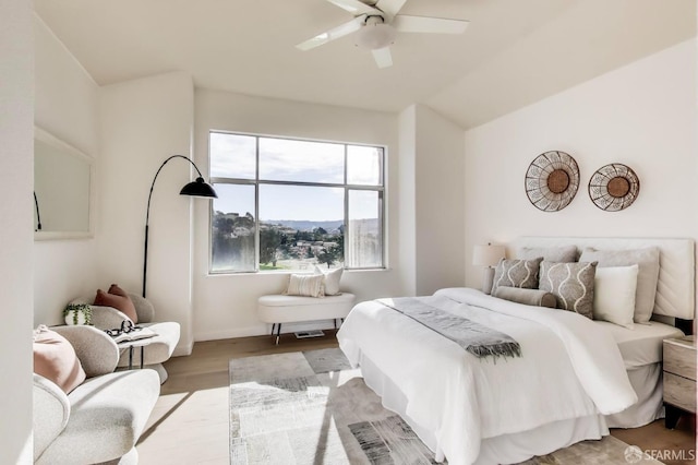 bedroom with lofted ceiling, light hardwood / wood-style floors, and ceiling fan