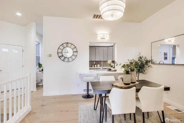 dining area with sink and light wood-type flooring